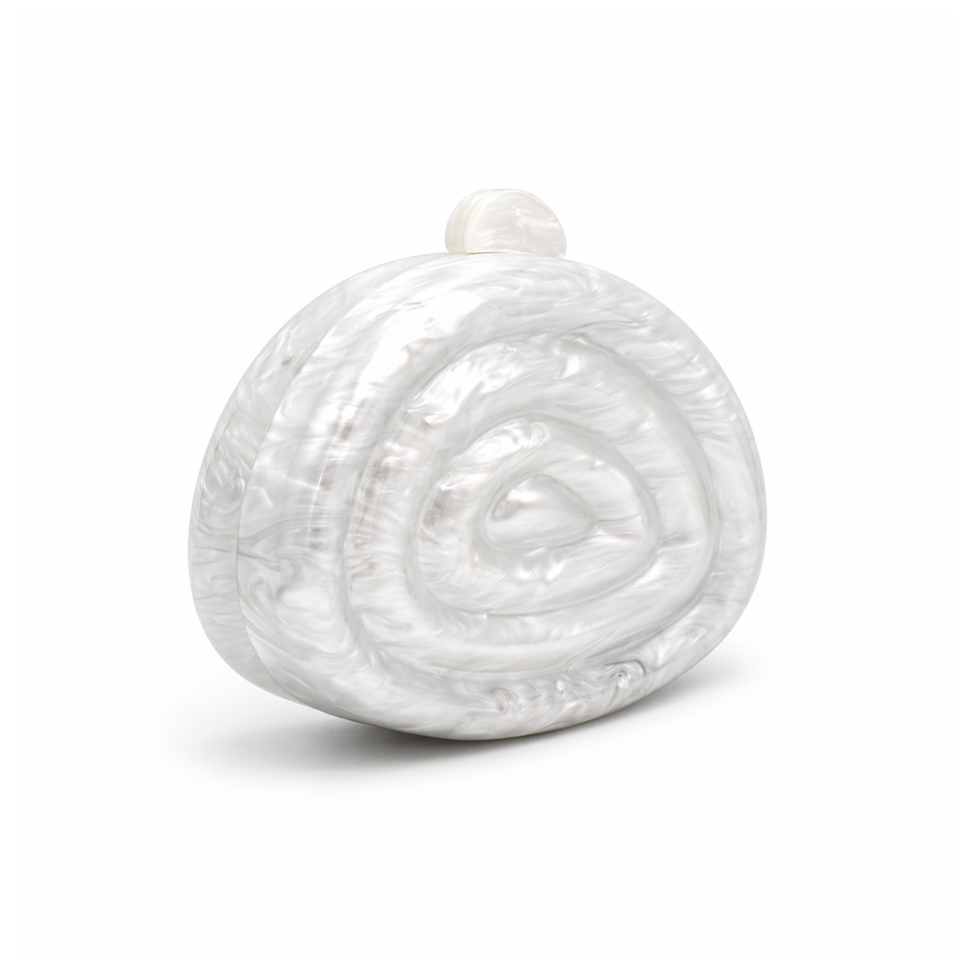 L’APOGÉE Zemira in White sculptural acrylic clutch featuring pearly white marbled textures, an organic asymmetrical silhouette with concentric carved detailing, and a glossy luxury finish designed for bridal styling and elegant evening occasions.