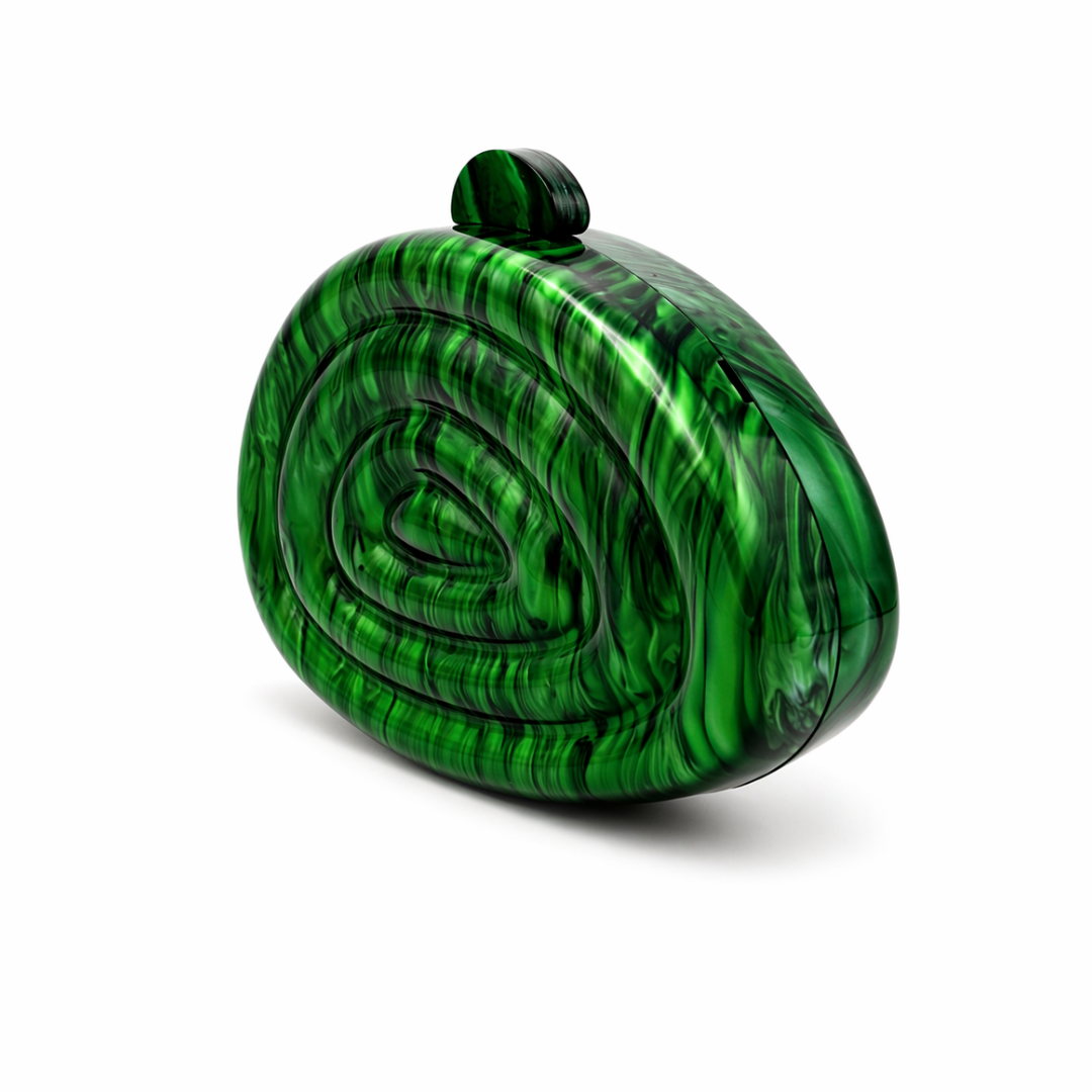 L’APOGÉE Zemira in Green sculptural acrylic clutch featuring rich emerald green marbled textures, an organic asymmetrical silhouette with concentric carved detailing, and a glossy statement finish designed for bold evening styling and luxury fashion events.