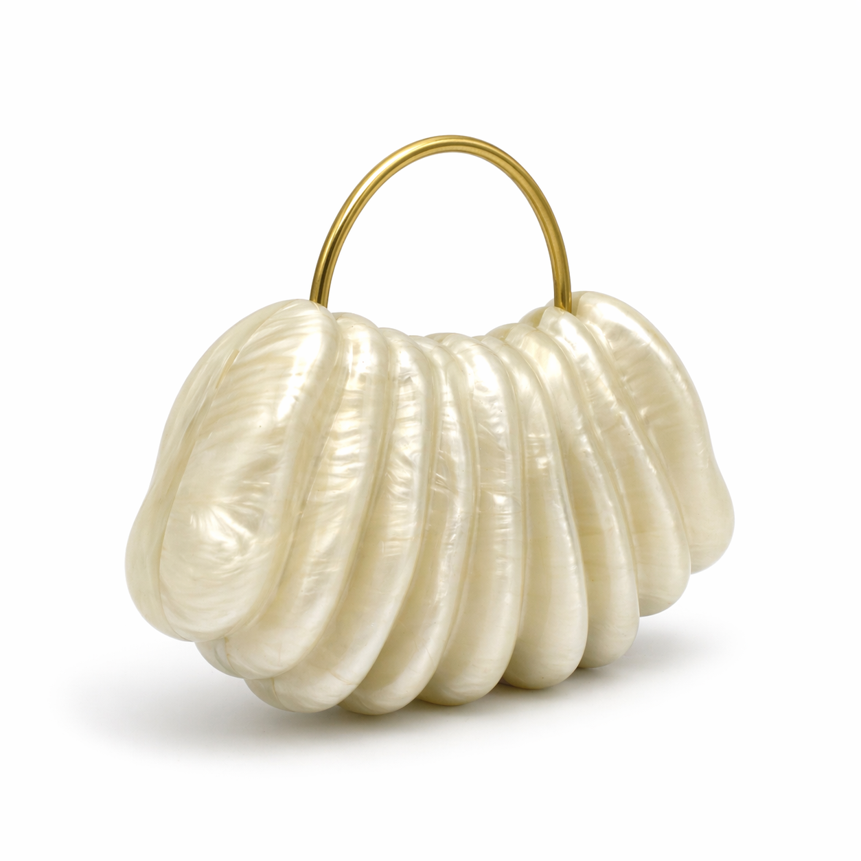 L’APOGÉE Ondée shell-inspired evening bag featuring pearly ivory finishes, sculptural ridged textures, and a sleek metallic top handle designed for bridal styling and elegant luxury fashion looks.