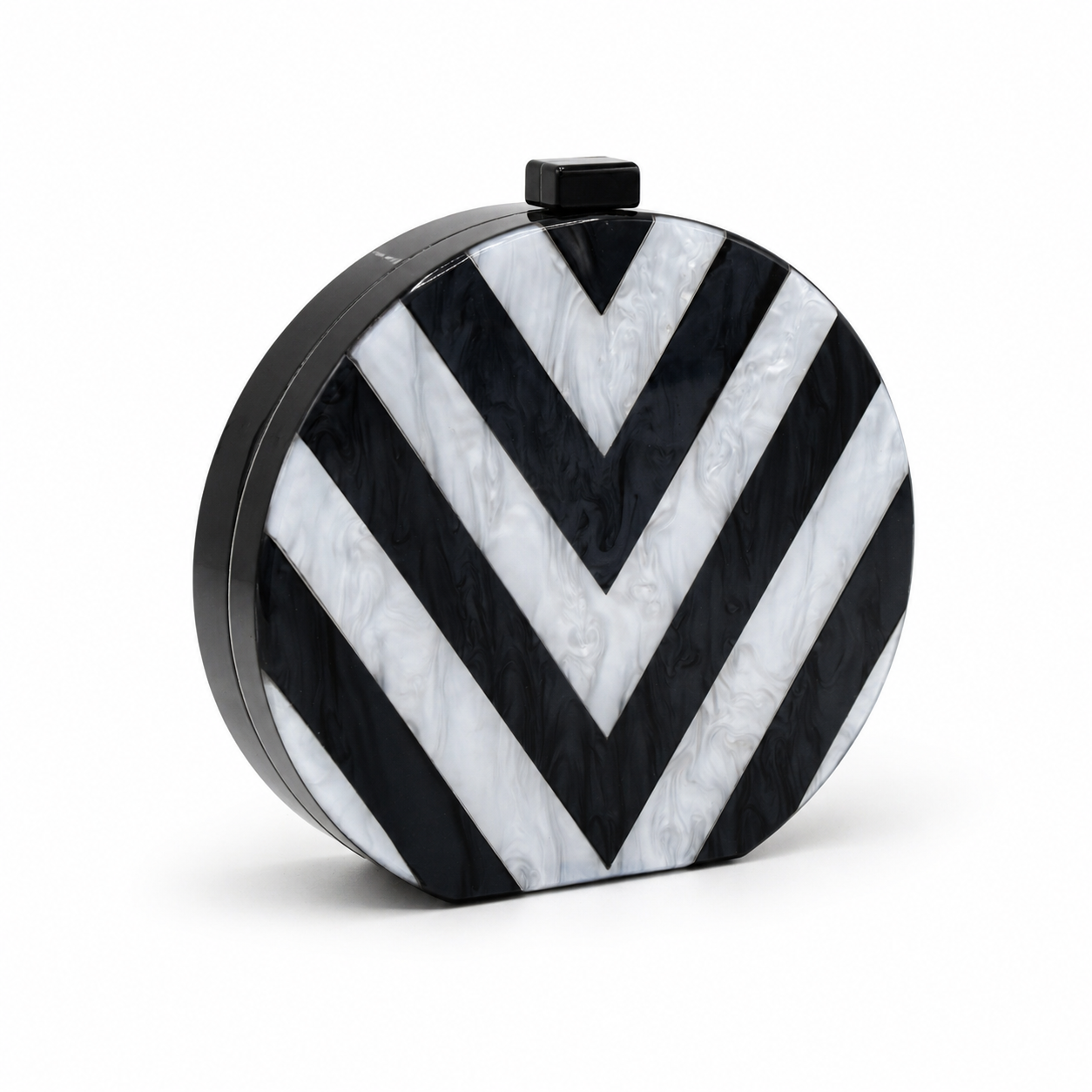 L’APOGÉE Chroma round acrylic clutch featuring bold black and white geometric striped patterns with a sculptural circular silhouette designed for modern evening styling and monochrome fashion statements.