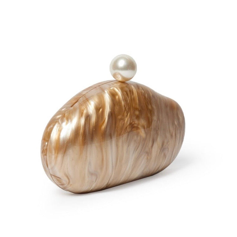 L’APOGÉE Alméa in Caramel sculptural acrylic clutch featuring glossy caramel marbled textures, a smooth organic silhouette, and pearl-inspired detailing designed for sophisticated evening styling and statement fashion looks.