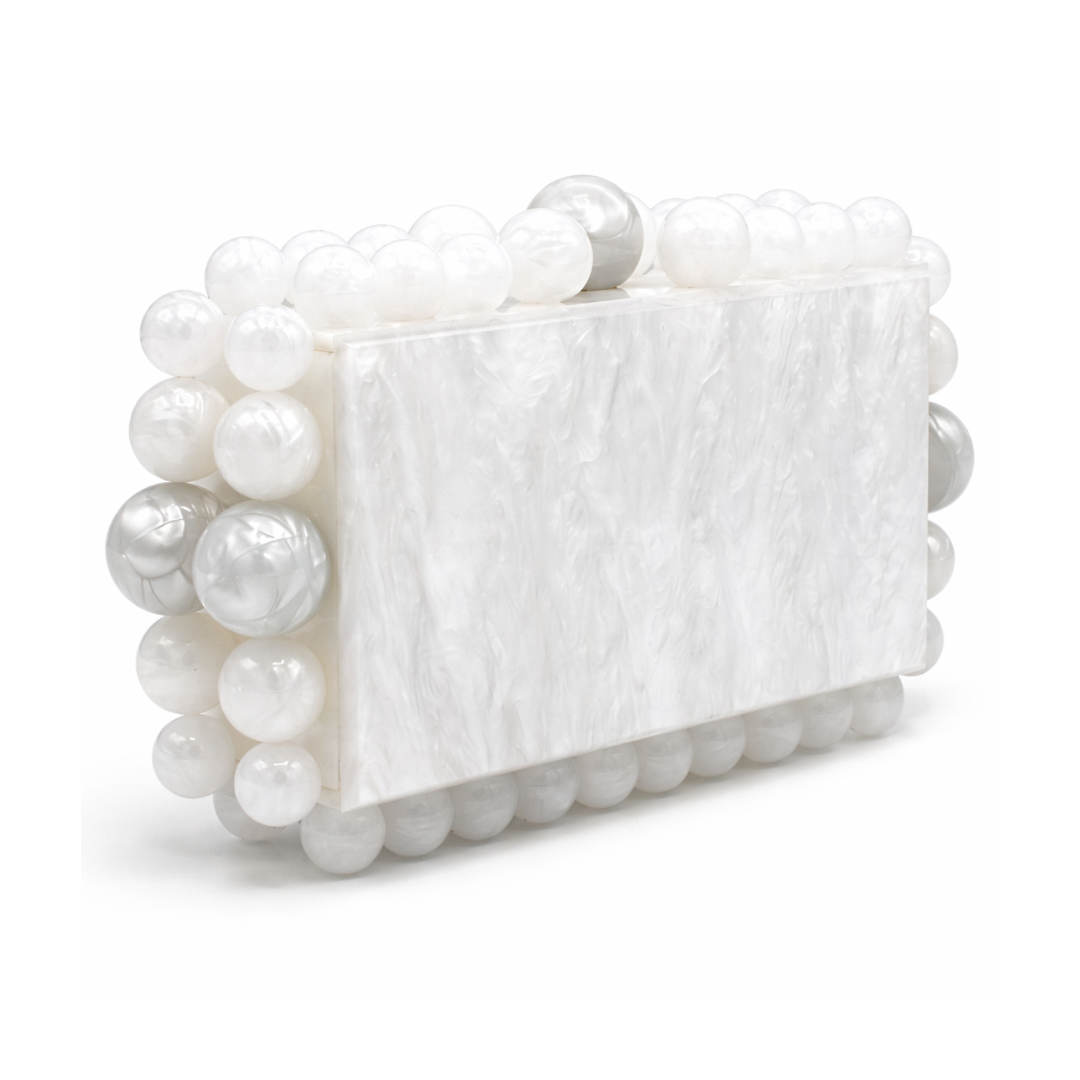 L’APOGÉE Boba in White acrylic evening bag featuring pearly white marbled finishes, sculptural pearl-inspired bead detailing, and a structured rectangular silhouette designed for bridal styling and elegant luxury occasions.