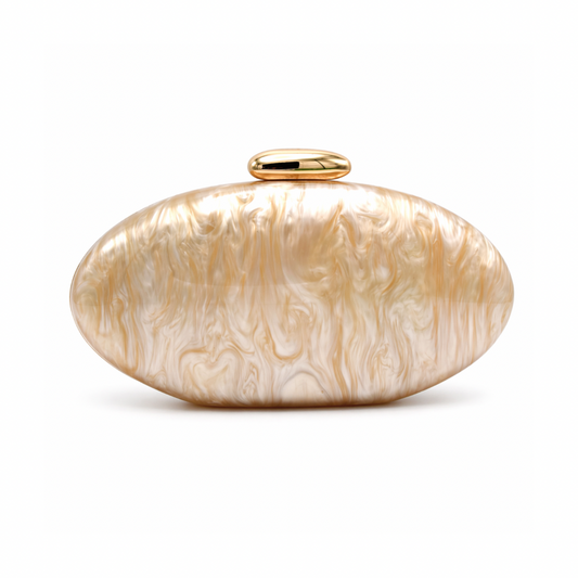 L’APOGÉE Arené oval acrylic clutch featuring golden beige pearlescent marbled textures, an elongated sculptural silhouette, and a sleek metallic gold clasp designed for elegant dinners, weddings, and sophisticated evening styling.