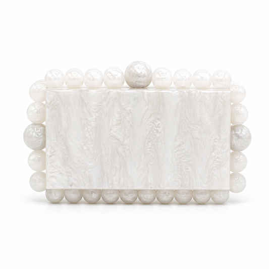 L’APOGÉE Boba in White acrylic evening bag featuring pearly white marbled finishes, sculptural pearl-inspired bead detailing, and a structured rectangular silhouette designed for bridal styling and elegant luxury occasions.