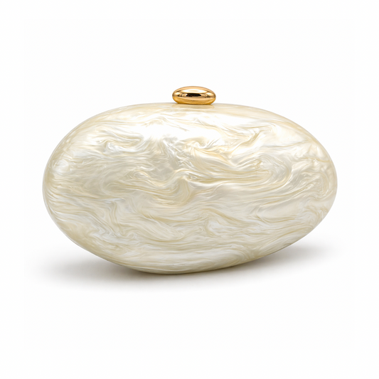 L’APOGÉE Calypso in Ivory sculptural oval acrylic evening bag featuring pearly ivory marbled tones and a rounded statement silhouette designed for weddings, luxury dinners, and elegant occasion styling.