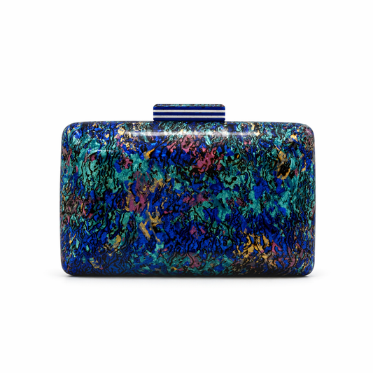 L’APOGÉE Celestia acrylic clutch featuring luminous blue iridescent textures, a glossy rectangular silhouette, and modern metallic detailing designed for luxury evening styling and artistic statement fashion looks.