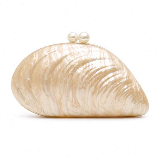 L’APOGÉE Elefteria beige shell-shaped evening bag featuring a sculptural glossy design for weddings, formal events, vacations, and elegant statement occasion styling.