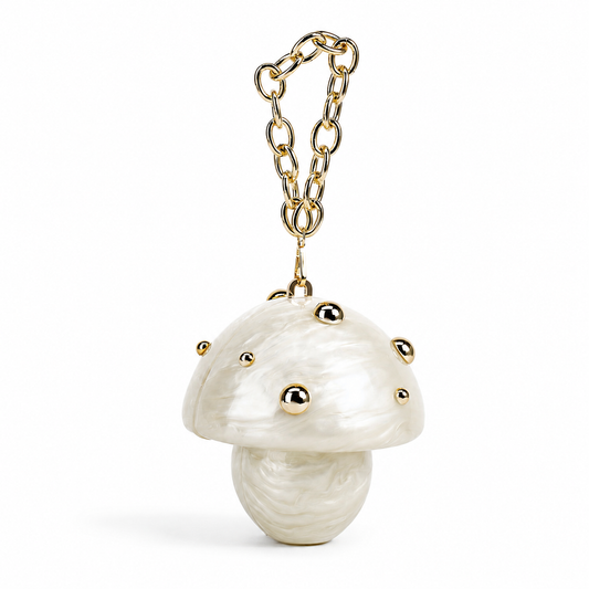 L’APOGÉE Fungo in Ivory sculptural mushroom acrylic clutch featuring pearly ivory marbled textures, gold stud detailing, and a gold chain handle designed for whimsical luxury styling and fashion-forward evening looks.