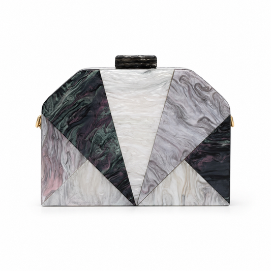 L’APOGÉE Nocturne geometric acrylic clutch featuring smoky black, charcoal, ivory, and grey marbled tones with a sculptural angular silhouette designed for formal events, dinners, and sophisticated evening styling.