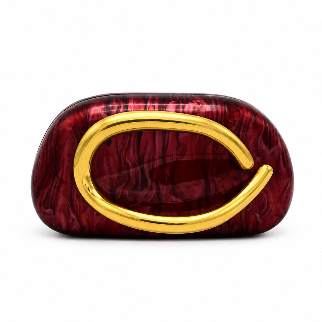 L’APOGÉE Promise in Burgundy sculptural acrylic clutch featuring a deep burgundy marbled finish, rounded cloud-inspired silhouette, and oversized gold statement handle designed for formal dinners, cocktail parties, and bold evening styling.