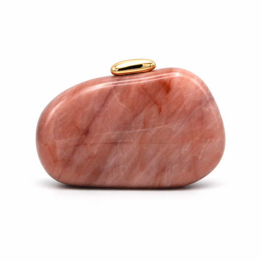 L’APOGÉE Puissance in Blush Quartz sculptural oval acrylic evening bag featuring soft blush quartz marbled tones and a glossy gold clasp designed for weddings, dinners, and elegant statement occasion styling.