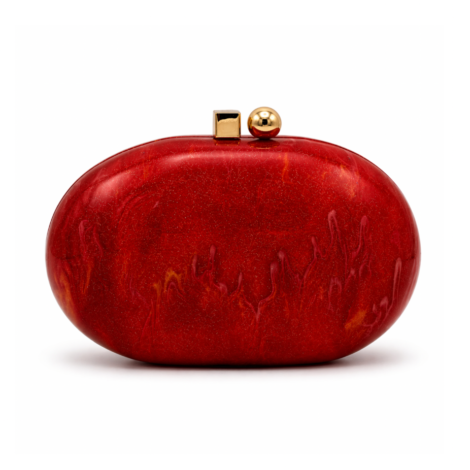 L’APOGÉE Rubelle oval acrylic clutch featuring glossy ruby red marbled textures, a smooth sculptural silhouette, and gold metallic clasp detailing designed for glamorous evening styling and statement party looks.