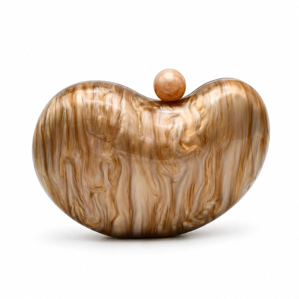 L’APOGÉE Solace in Caramel sculptural rounded acrylic evening bag featuring warm caramel marbled tones, glossy finish, and chunky gold chain detailing designed for dinners, formal events, and elegant occasion styling.