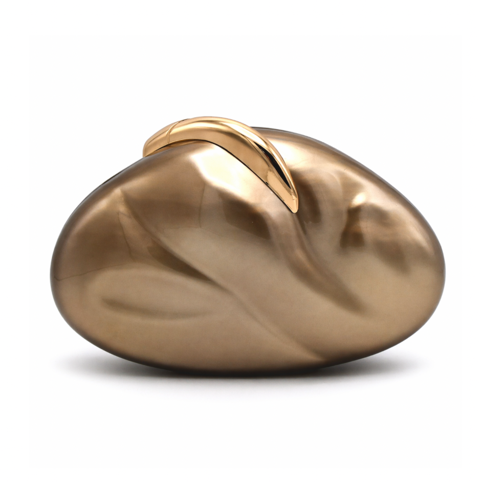 L’APOGÉE Sovana in Brown acrylic clutch featuring warm caramel brown marbled tones, a smooth pebble-inspired silhouette, and sculptural gold metallic handle designed for chic dinner parties and sophisticated evening styling.