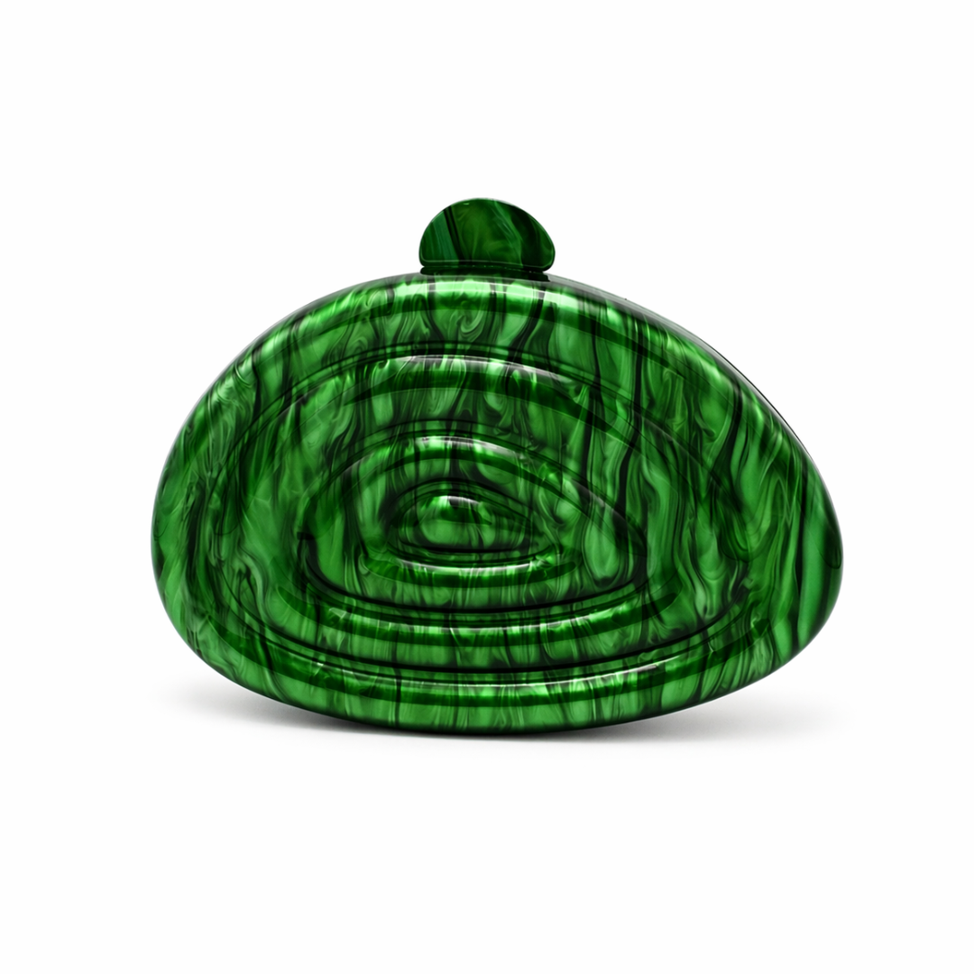 L’APOGÉE Zemira in Green sculptural acrylic clutch featuring rich emerald green marbled textures, an organic asymmetrical silhouette with concentric carved detailing, and a glossy statement finish designed for bold evening styling and luxury fashion events.
