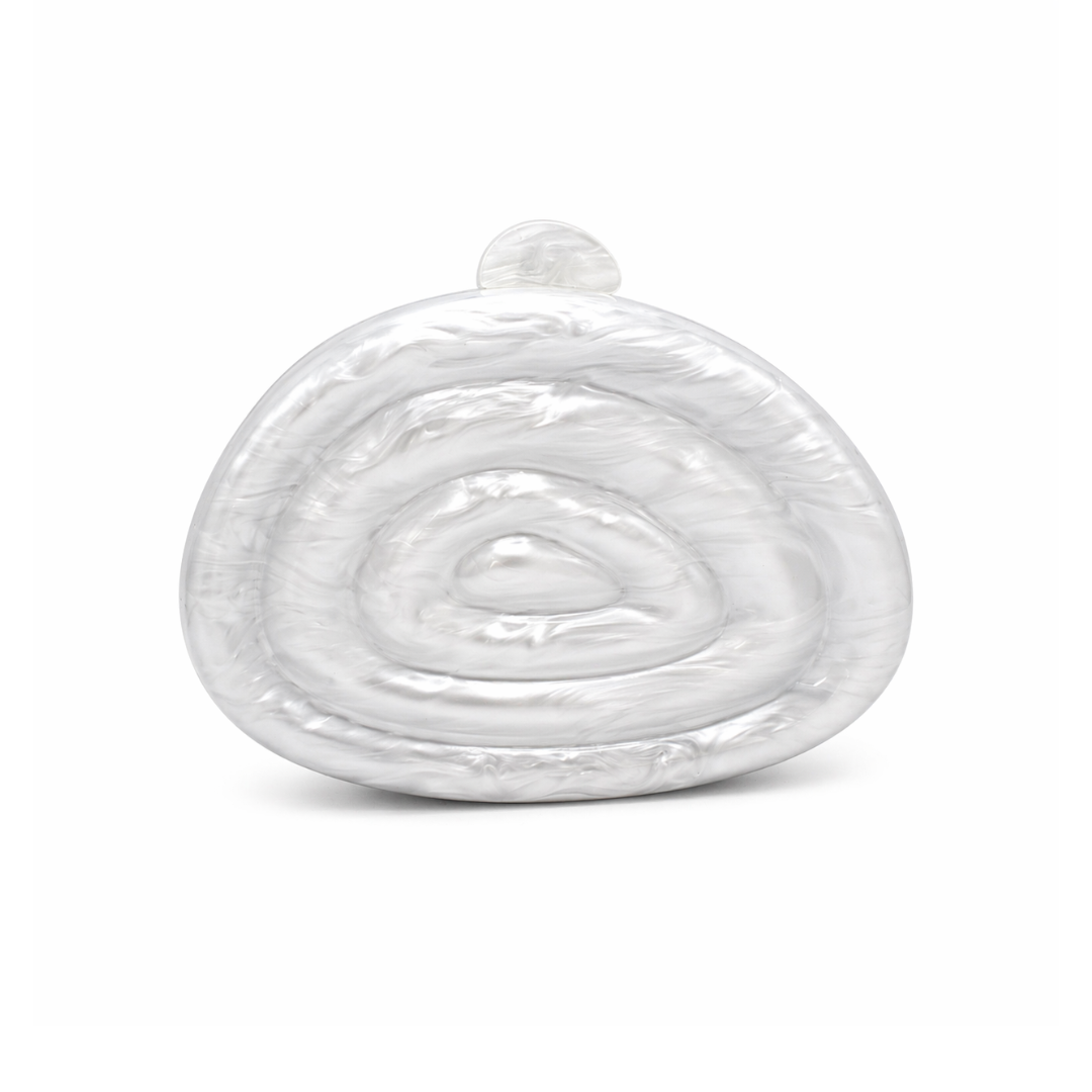 L’APOGÉE Zemira in White sculptural acrylic clutch featuring pearly white marbled textures, an organic asymmetrical silhouette with concentric carved detailing, and a glossy luxury finish designed for bridal styling and elegant evening occasions.