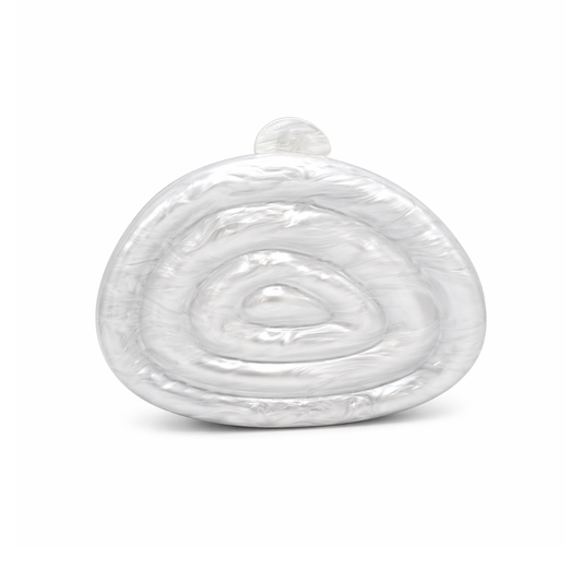 L’APOGÉE Zemira in White sculptural acrylic clutch featuring pearly white marbled textures, an organic asymmetrical silhouette with concentric carved detailing, and a glossy luxury finish designed for bridal styling and elegant evening occasions.